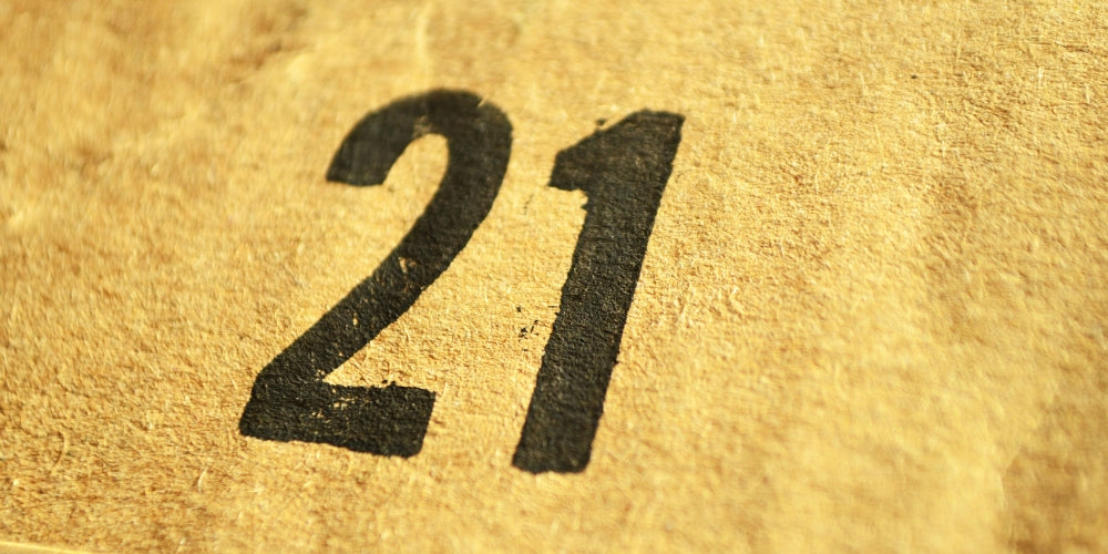 chiffre 21 imprimé sur papier craft doré symbolisant l'heure miroir 21h21 et l'amour