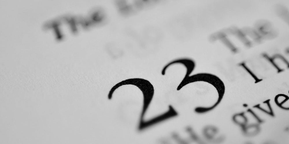 chiffre 23 imprimé en gros dans un livre ouvert symbolisant l'heure miroir 23h23 et le lâcher-prise
