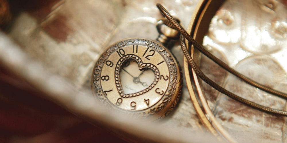 montre à gousset dorée en forme de coeur symbolisant les heures miroir et la numérologie