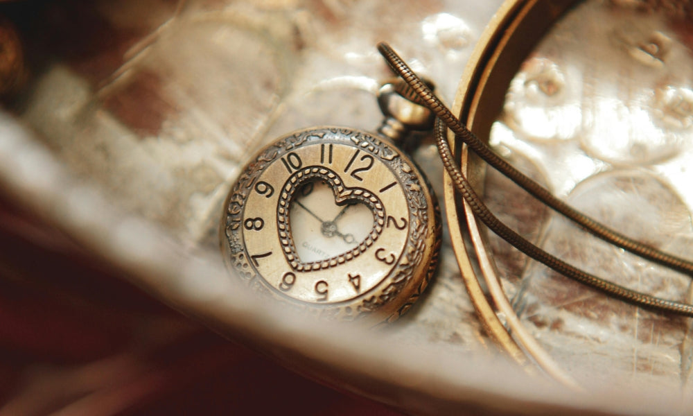 montre à gousset dorée en forme de coeur symbolisant les heures miroir et la numérologie